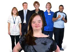 A young woman is standing in front of five other people. She has a disability and has her hands on her hips, she looks confident. Behind her are a nurse, a man and a woman in a suit, a woman in a blue uniform and a young man with his thumbs up.