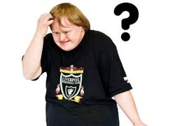 A man in a black t shirt  is scratching his head, looking confused 